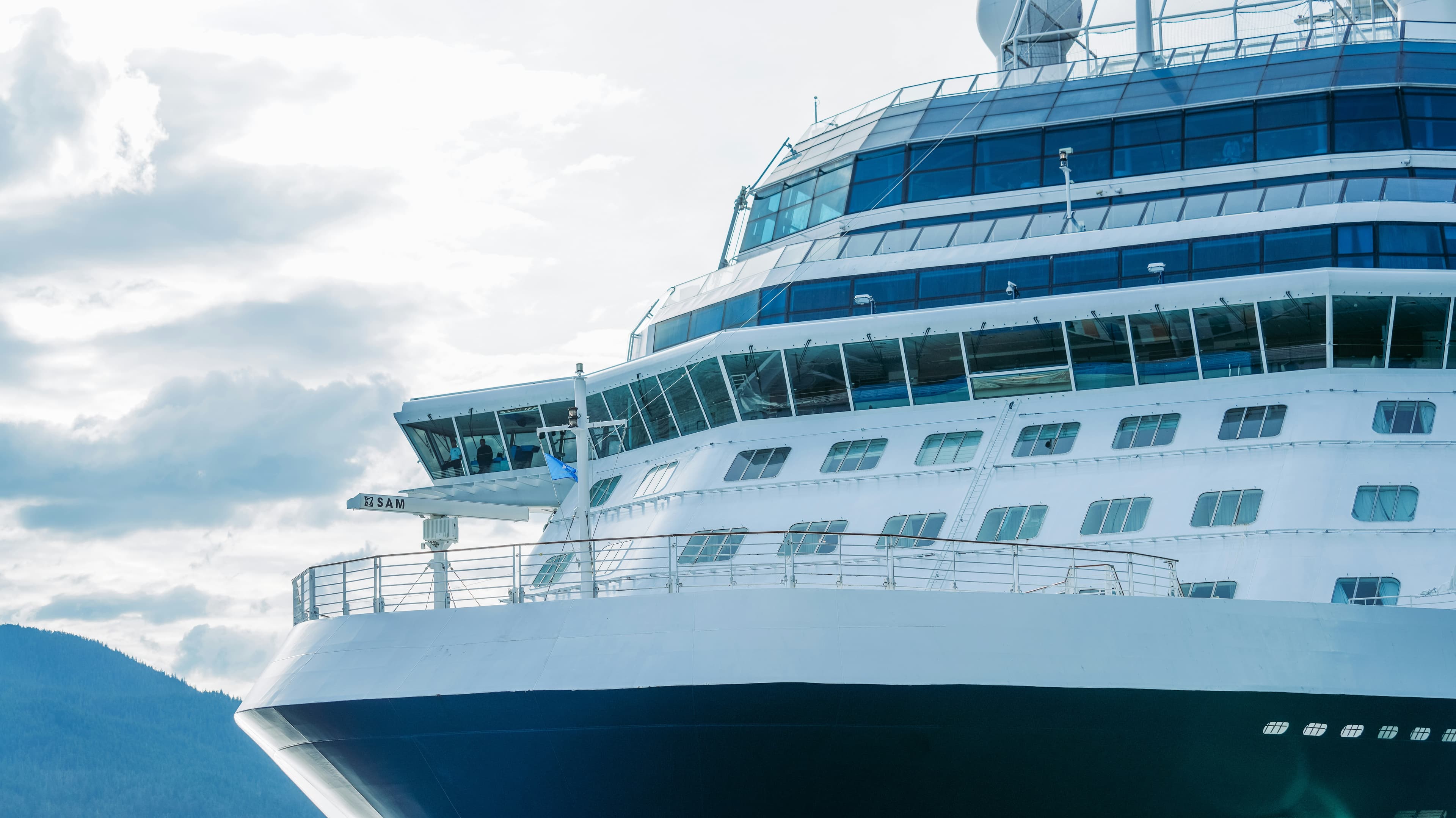 A cruise ship in Juneau, Alaska with mountains and water behind it.