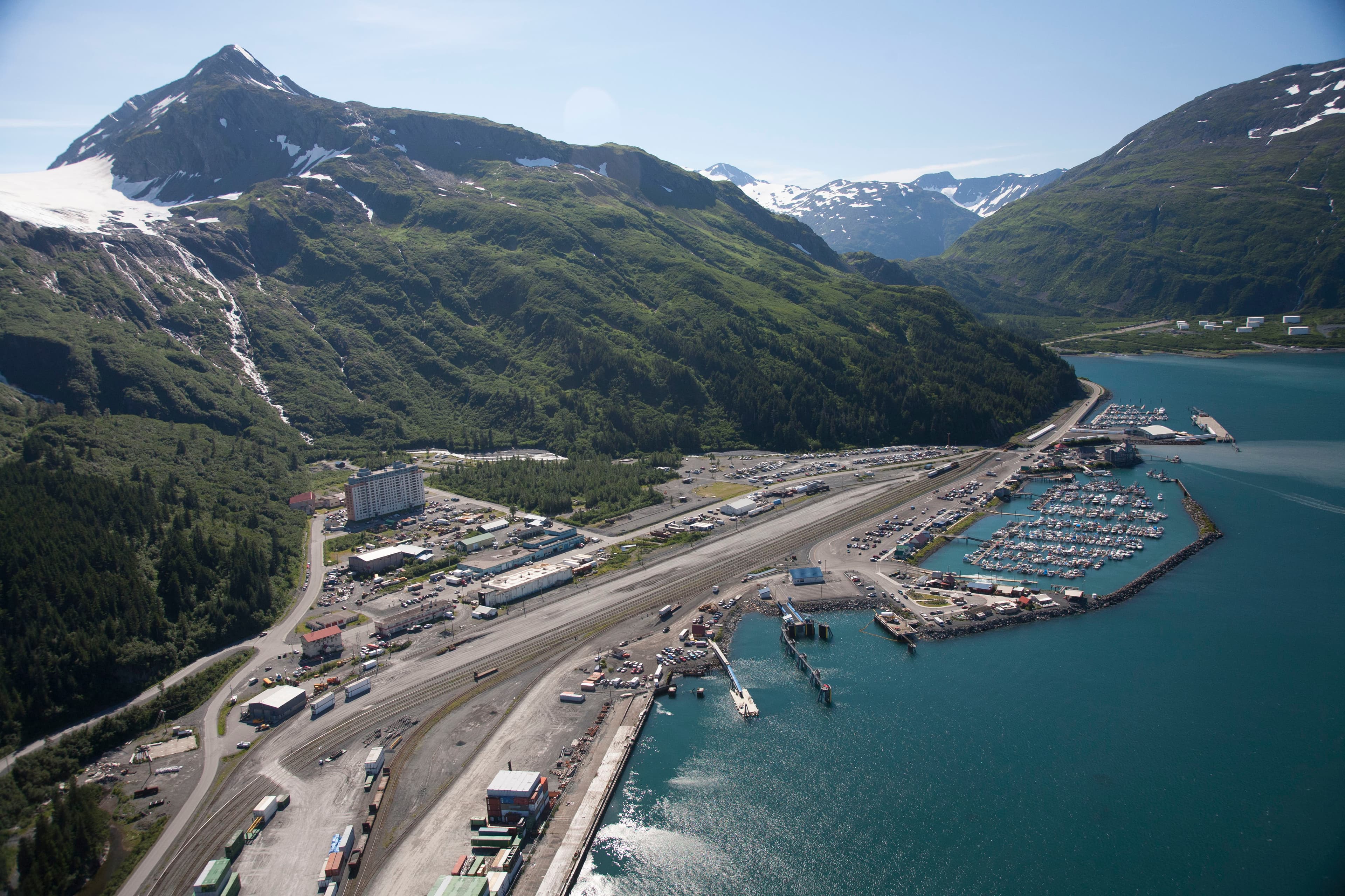 Aerial view of Whittier, Alaska surrounded by mountains and water.